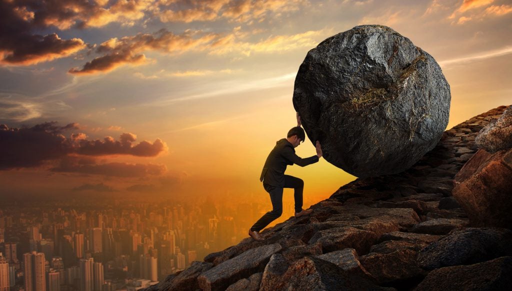 Man rolling boulder uphill