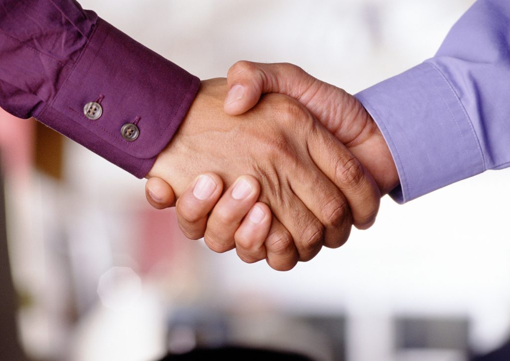 Two men shaking hands to close a sale