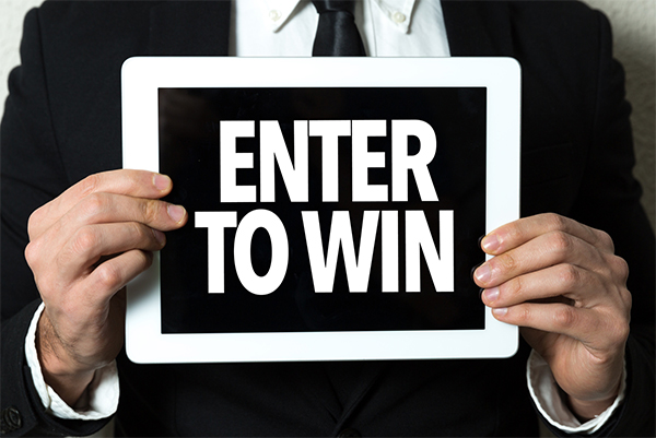 man holding sign that says enter to win