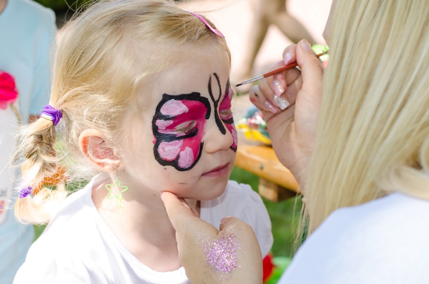 little girl getting face painting of butterfly