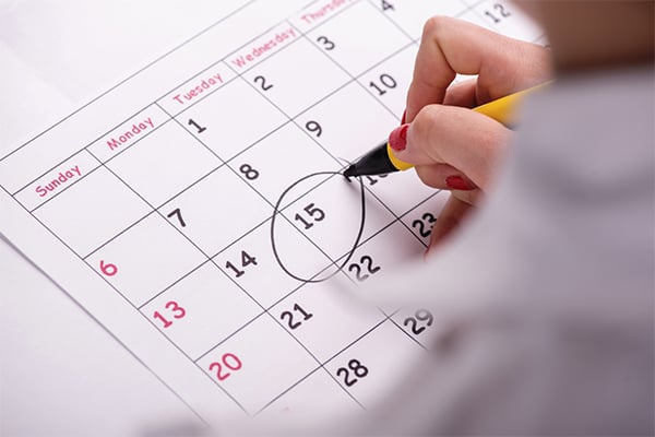 hand circling date on a calendar