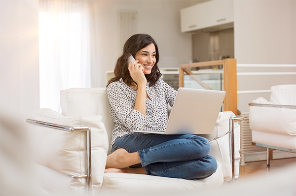 woman on laptop talking on phone